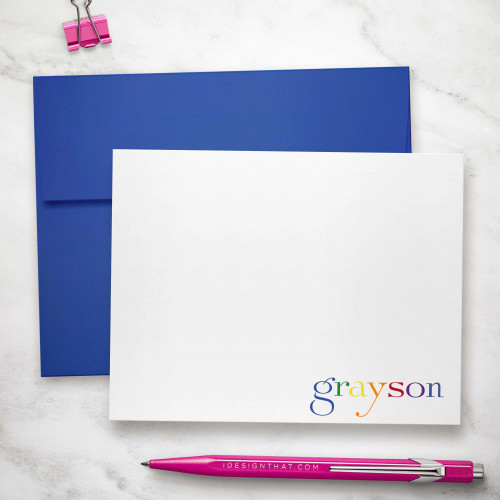 Rainbow flat notecard showing rainbow-colored name at the lower edge with a blue envelope.