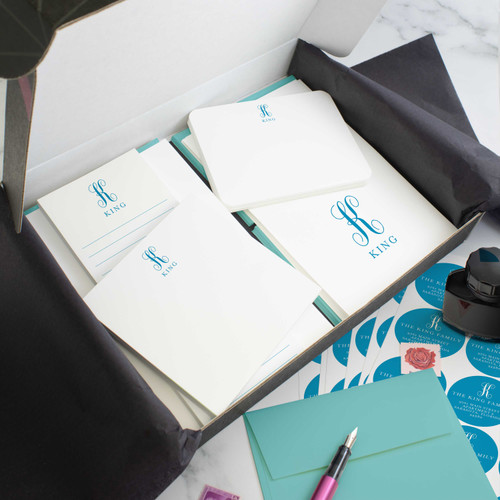Family Monogram personalized stationery gift set in an open box with coordinated notecards, notepads, envelopes, and stickers.