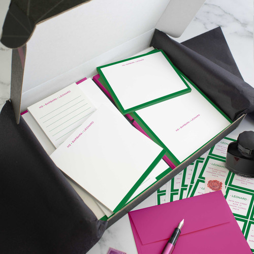 Modern Border stationery gift set in an open box with green-bordered cards, notepads, address stickers, and fuchsia envelopes.
