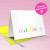 Folded kids stationery notecard featuring rainbow name design and bright envelope, shown from side angle