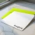 Holla Swash flat notecard with rounded corners and black Monica script, resting on a lime-green envelope on a sunlit marble desk by a window.