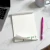 Holla Swash rectangular notepad with a green script name and curled pages, shown beside a pink pen, laptop and gray coffee cup.
