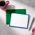 Custom flat notecard personalized with a three-part name, blue border, and coordinating green envelope.