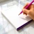 Hand writing on a Modern Border personalized notepad with an honorific and full name, showing the open unlined writing surface.
