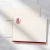 Red-bordered personalized flat notecard with red monogram and coordinating envelopes