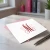 Traditional Script folded monogram notecard with a red and soft pink three-initial design, coordinating pink envelope, and silver pen.
