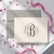 Folded monogram stationery card with a neutral three-initial Traditional Script design, gray envelope, pink ribbon, and star confetti.