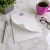 Custom stationery memo pad with a teal and brown Traditional Script monogram, curled paper, coffee, glasses, and pen.