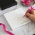 Simple Calligraphy personalized square notepad with a name printed at the bottom while someone writes