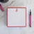 Red-bordered personalized square notepad with red monogram and pink pen