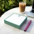 Green personalized square notepad with monogram, iced coffee, and laptop