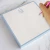 Light blue personalized square notepad with monogram and hand writing with pink pencil