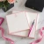 Pink personalized square notepads with monograms, flowers, ribbon, and pen