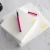 Overlapping Holla Swash custom square notepads with yellow script names and sweeping swashes, shown with a pink fountain pen.