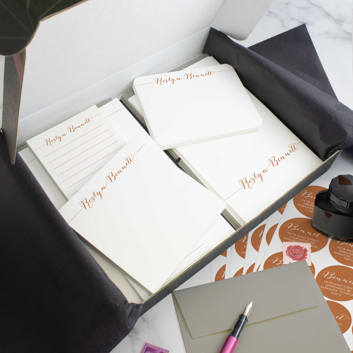Simple Calligraphy personalized stationery gift set in an open box with coordinated notecards, notepads, envelopes, and stickers.