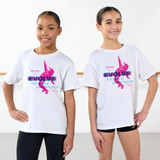 Two children wearing white T‑shirts with a colorful “Evolve The Spring Performance 2026” graphic, standing in a dance studio.