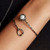 Circle and Pearl Crossover Bracelet from Brenda Smith on model | Oxidized Sterling Silver and 14 Karat Yellow Gold | Pearl and Diamonds Circle and Pearl Crossover Bracelet from Brenda Smith on model | Oxidized Sterling Silver and 14 Karat Yellow Gold | Pearl and Diamonds