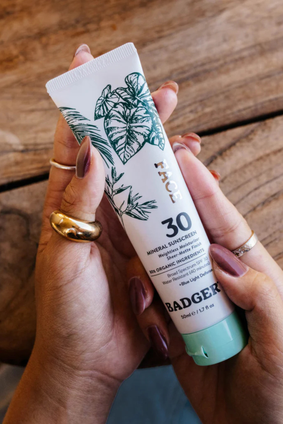 hands hold badger mineral sunscreen spf30 face