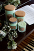 Inviting arrangement of light green candles on a piano with sheet music and sprigs of snow covered evergreen.