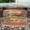 Copper finish spillway with LED lighting installed in a backyard water feature.