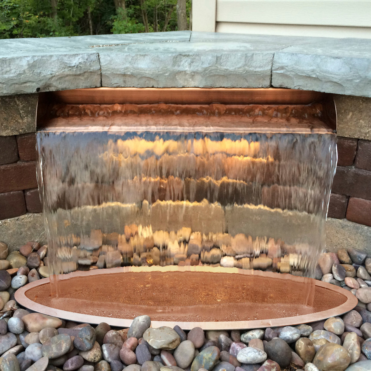 Copper-colored rectangular water spillway for ponds and fountains, designed for smooth cascading water flow.
