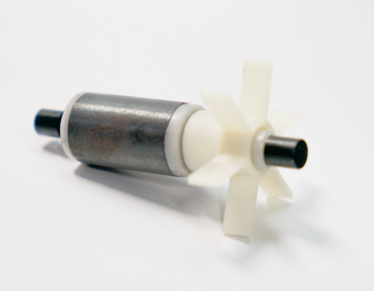 Angled view of the Bermuda 925 GPH impeller assembly, displaying the rotor fins, shaft ends, and end caps for seating inside the pump.