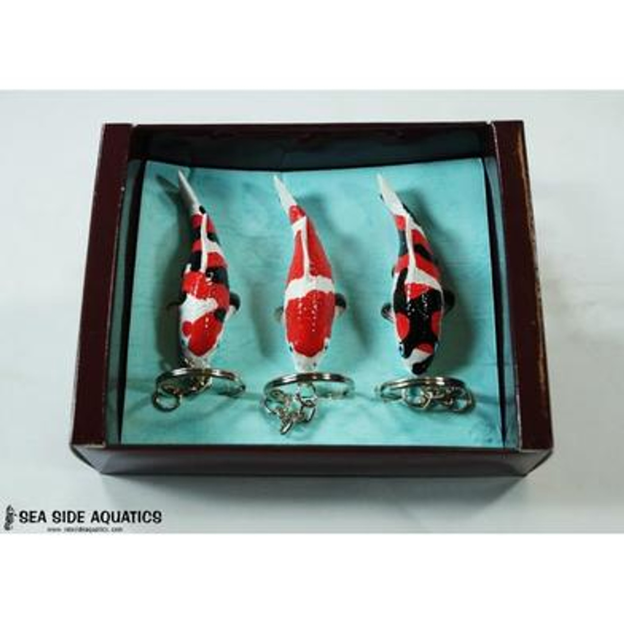 Set of three miniature koi fish keychains displayed in a presentation box, featuring black-and-white Shiro, golden Ogon, and white Tancho with a red spot.