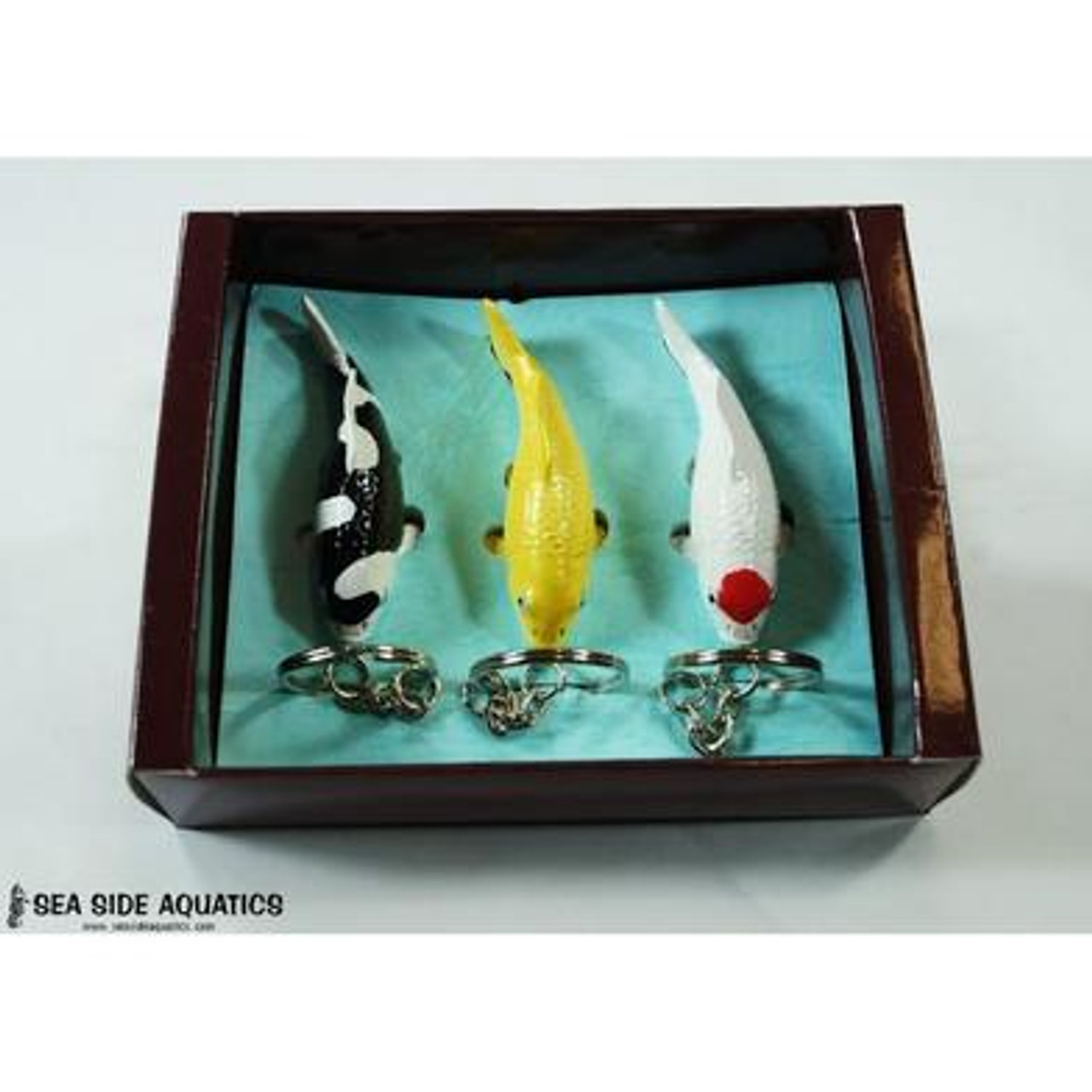 Set of three miniature koi fish keychains displayed in a presentation box, featuring black-and-white Shiro, golden Ogon, and white Tancho with a red spot.