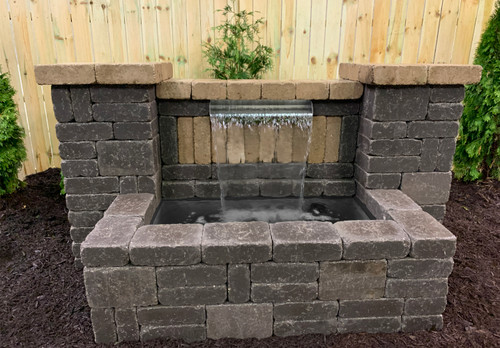 The spillway and liner set up in a water feature, with water flowing through the spillway. The spillway and liner set up in a water feature, with water flowing through the spillway.