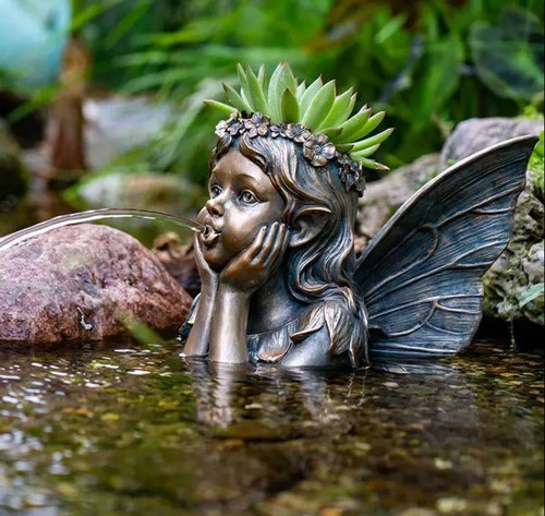 Fairy Planter Spitter shown in use in a garden or water feature, with water cascading gently from the fairy’s hand. Small plants are growing in the planter, adding a magical, serene ambiance to the outdoor space. Fairy Planter Spitter shown in use in a garden or water feature, with water cascading gently from the fairy’s hand. Small plants are growing in the planter, adding a magical, serene ambiance to the outdoor space.