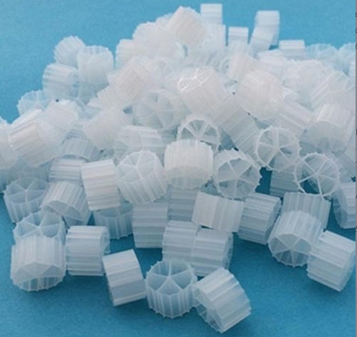 Front view of a small pile of Bio Comb fluidized bed media showing interlocking white plastic comb-shaped pieces with multiple parallel fins. Front view of a small pile of Bio Comb fluidized bed media showing interlocking white plastic comb-shaped pieces with multiple parallel fins.
