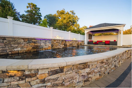Raised stone-walled pond beside a pool house
