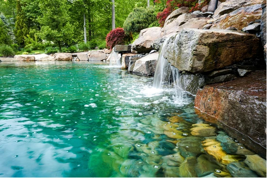 Clear turquoise pond fed by a rock waterfall
