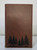 pine forest engraving on brown notebook journal