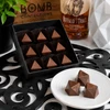 Open Bomb Confections Buffalo Trace Bourbon Bonbons featuring handcrafted bourbon-filled artisan chocolates in a premium gift box with three bonbons plated in front and a subtle Buffalo Trace bourbon accent.
