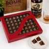 Luxury 40-piece Buffalo Trace Bourbon Bonbons by Bomb Confections displayed in a premium red window gift box with handcrafted artisan chocolates, subtle bourbon accents, and three bonbons presented in front.