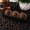 Three handcrafted Bourbon Espresso Coffee Bombs arranged in a black gift box with bourbon-inspired styling by Bomb Confections.