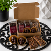 Open Bomb Confections Bourbon Discovery Collection displaying individually wrapped mini bourbon chocolate bars, handcrafted bourbon chocolate skulls, and bourbon pecan toffee inside a premium kraft gift box.