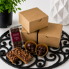 Gift-ready Bomb Confections Bourbon Discovery Collection featuring premium kraft packaging with individually wrapped bourbon chocolate bar, handcrafted bourbon chocolate skulls, and artisan bourbon pecan toffee.
