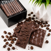 Close-up of handcrafted Espresso Mini Chocolate Bars with roasted coffee beans, showcasing the individually wrapped chocolates included in the Espresso Coffee Bomb Gift Set by Bomb Confections.