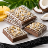 Piña Colada mini chocolate bars topped with white chocolate, pineapple and toasted coconut