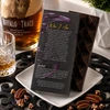 Back of Bomb Confections Bourbon Chocolate Bar packaging displayed with the artisan chocolate bar, featuring product story, ingredients, allergen information, and handcrafted branding with subtle Buffalo Trace bourbon accents.