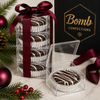 Chocolate-covered sandwich cookie with white chocolate drizzle in silver foil holiday gift packaging