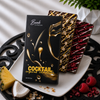 Bomb Confections gift package displayed with Piña Colada and Raspberry Daiquiri rum chocolate bars, featuring tropical pineapple, coconut, and raspberry flavor accents.