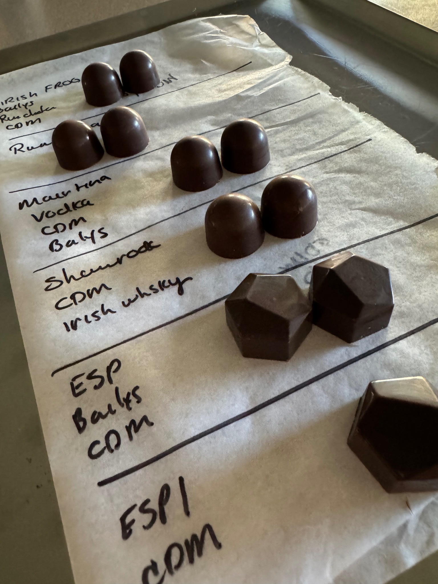 Handwritten Bomb Confections bonbon recipe testing notes with sample chocolates