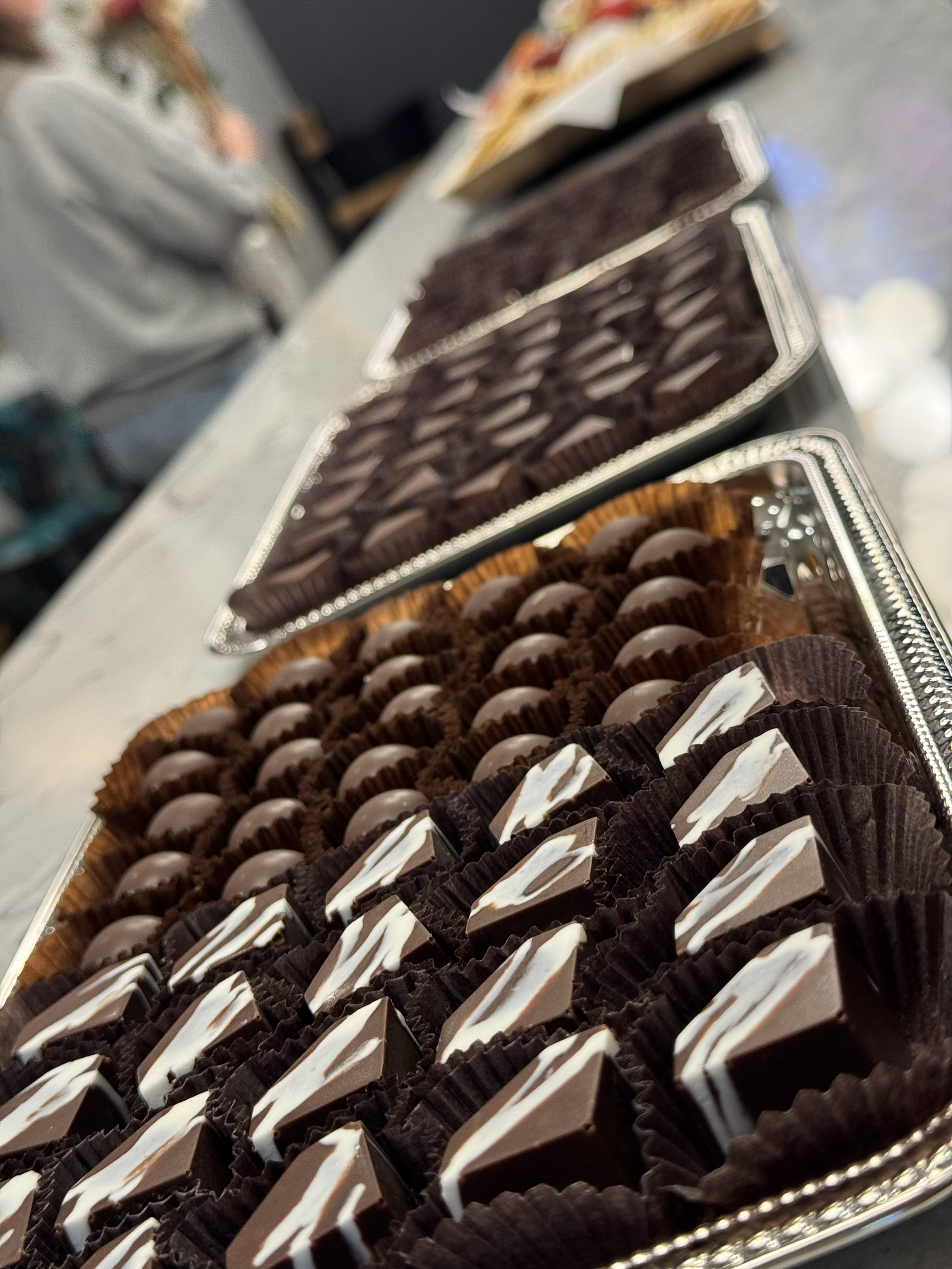 Bomb Confections handcrafted bonbons displayed on silver trays for an event