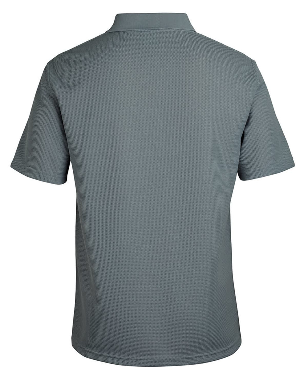 A polo shirt in a muted green colour, featuring a textured fabric and a collar. The back view is displayed. 