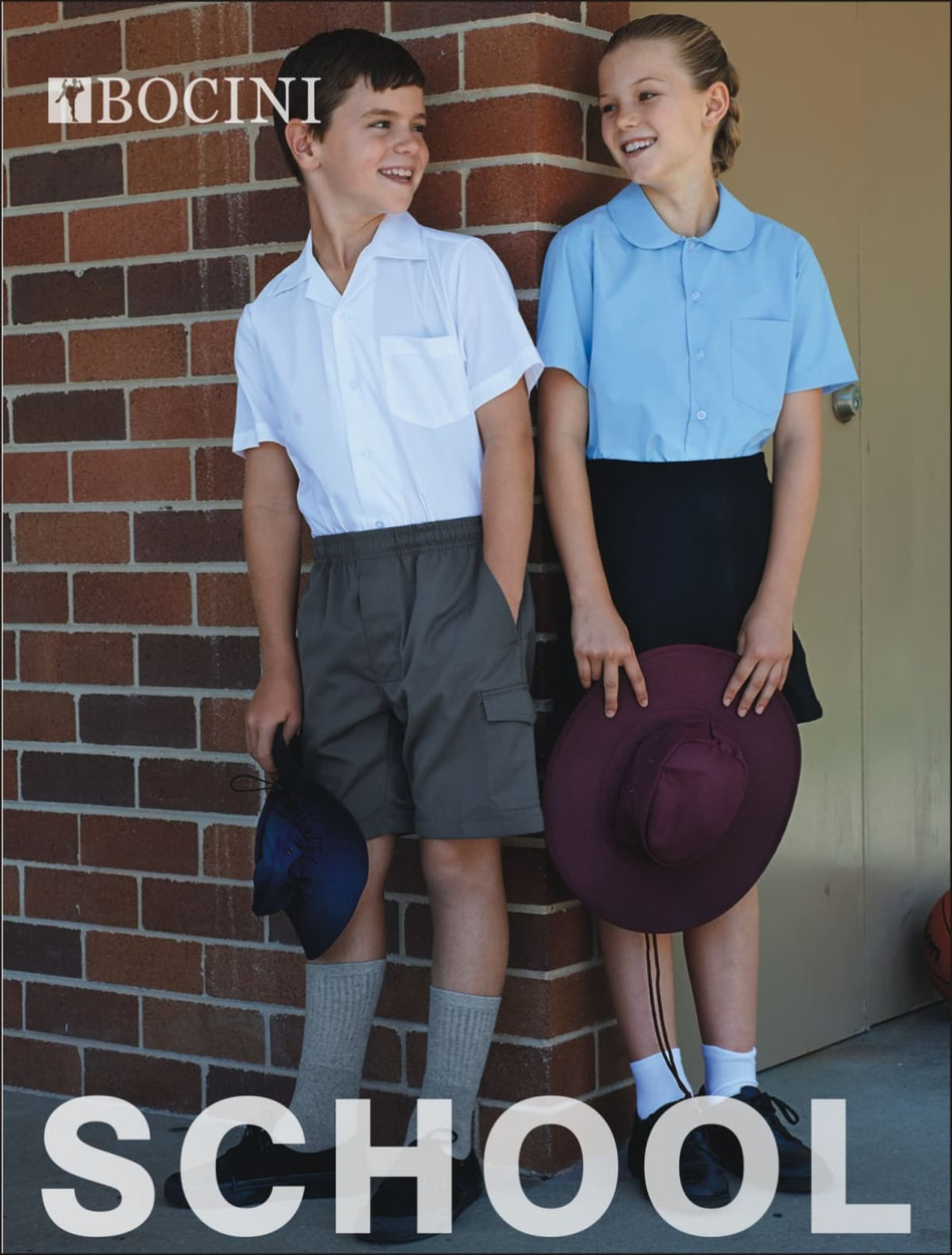 A boy in a white shirt and khaki shorts stands next to a girl in a blue shirt and black skirt, both wearing hats.