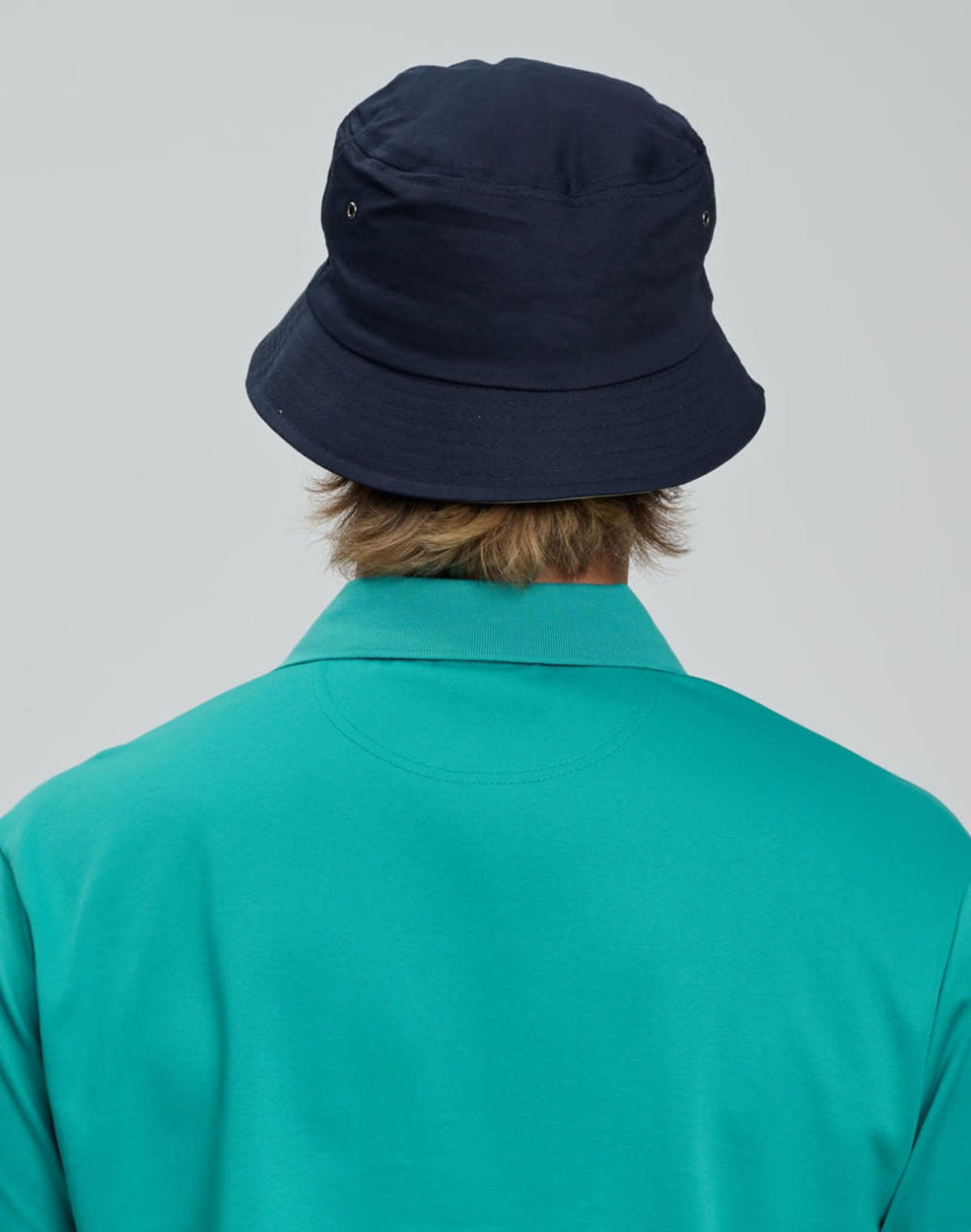 A navy bucket hat with a contrasting underbrim, shown from the back, paired with a teal shirt.
