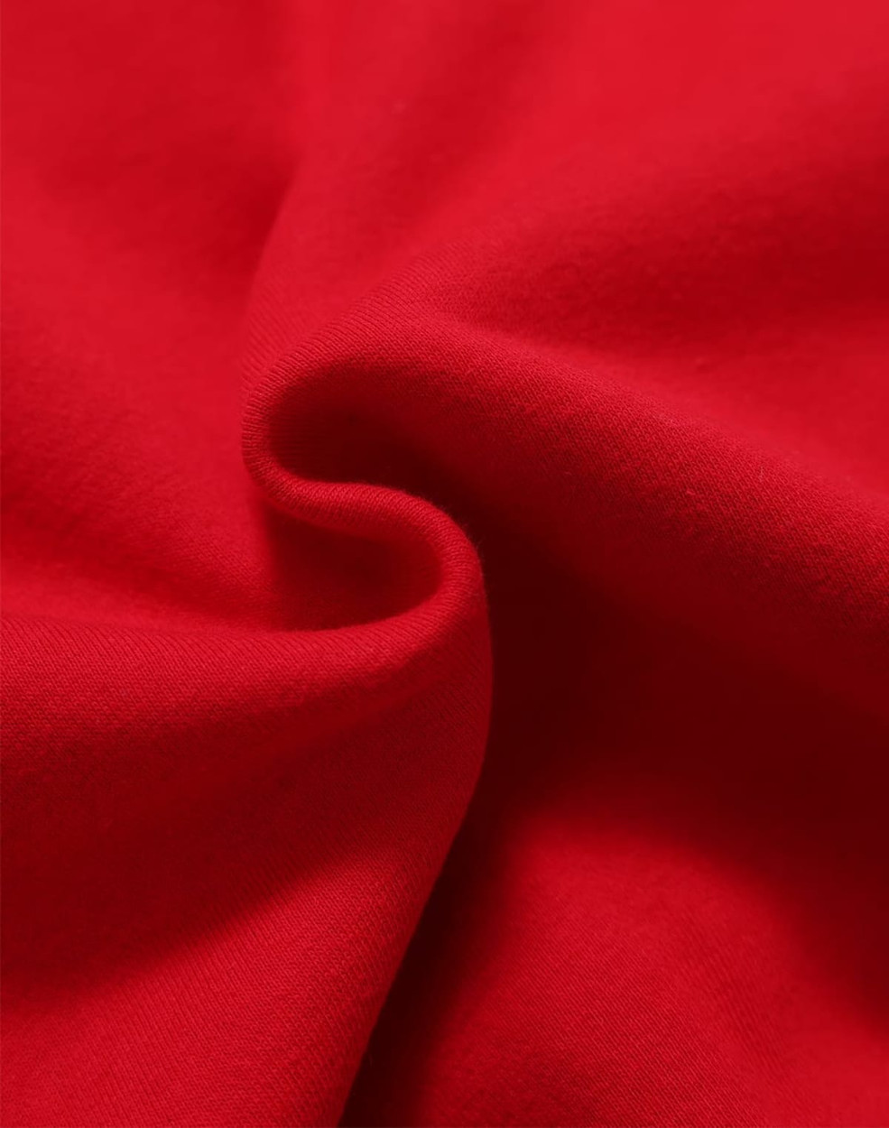 A close-up view of soft, red fleece fabric showing its textured surface. The image features a subtle fold in the material.